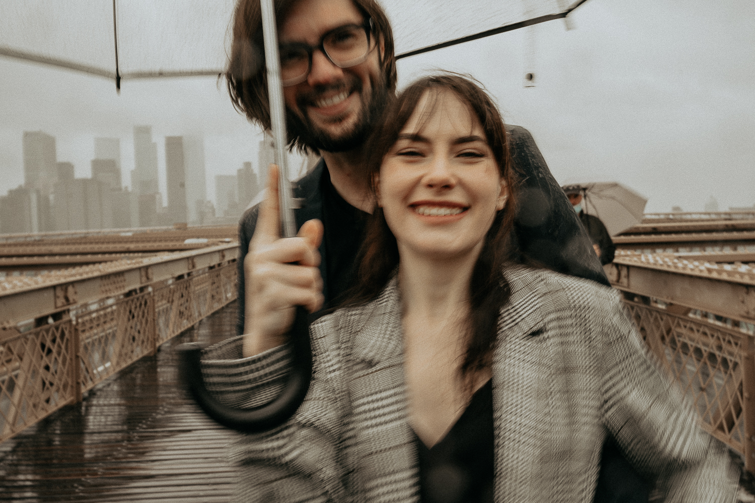 couples photoshoot in the rain on brooklyn bridge in nyc
