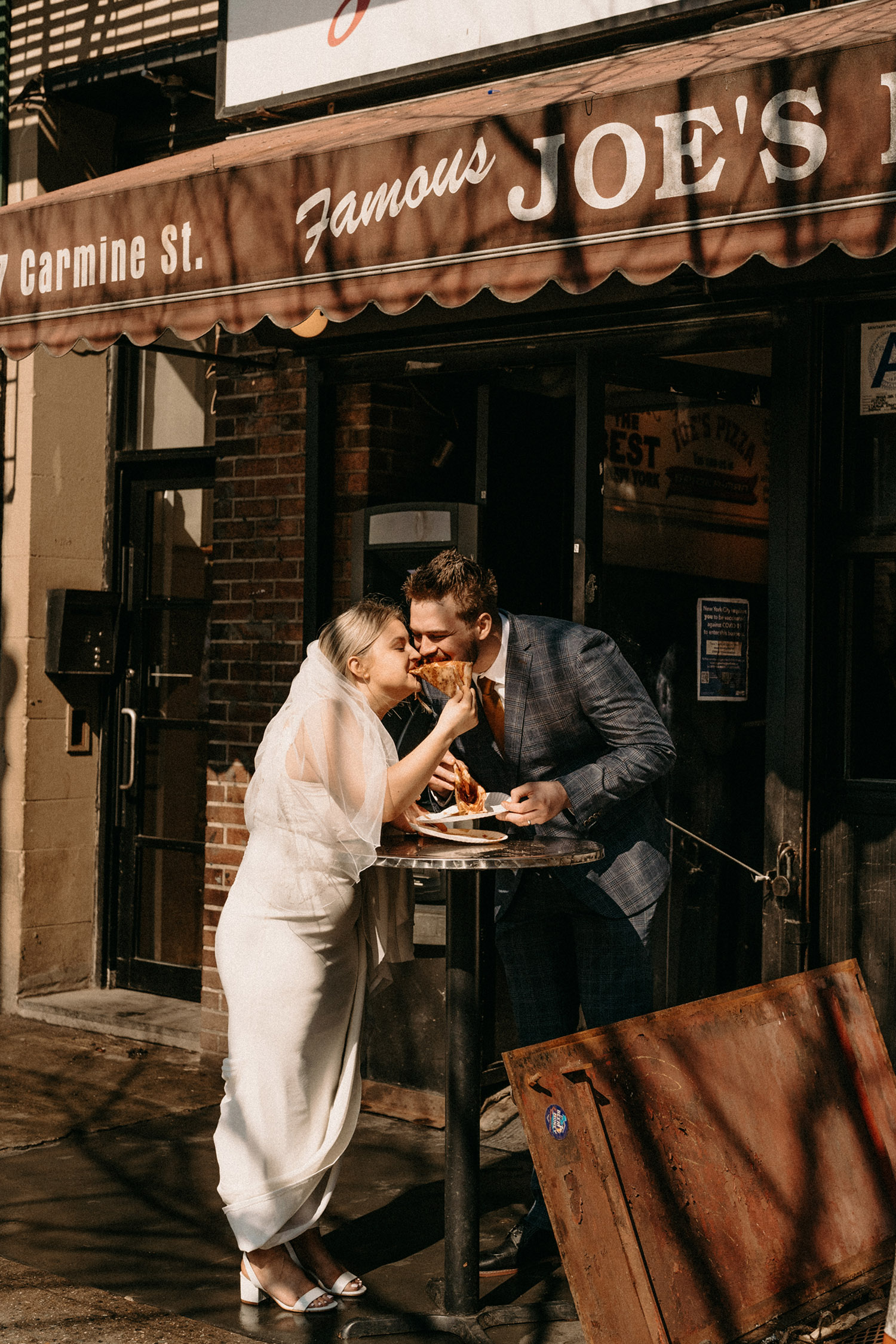 Couple sharing pizza together on their elopement day in West Village New York City