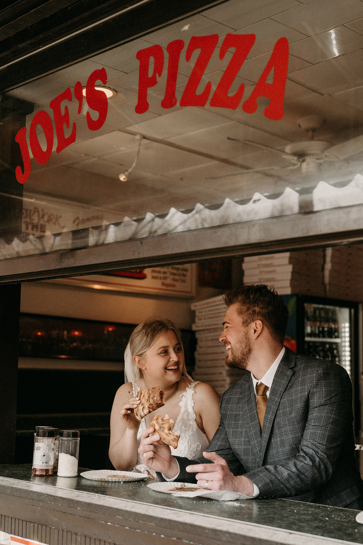 Couple sharing pizza together on their elopement day in West Village New York City