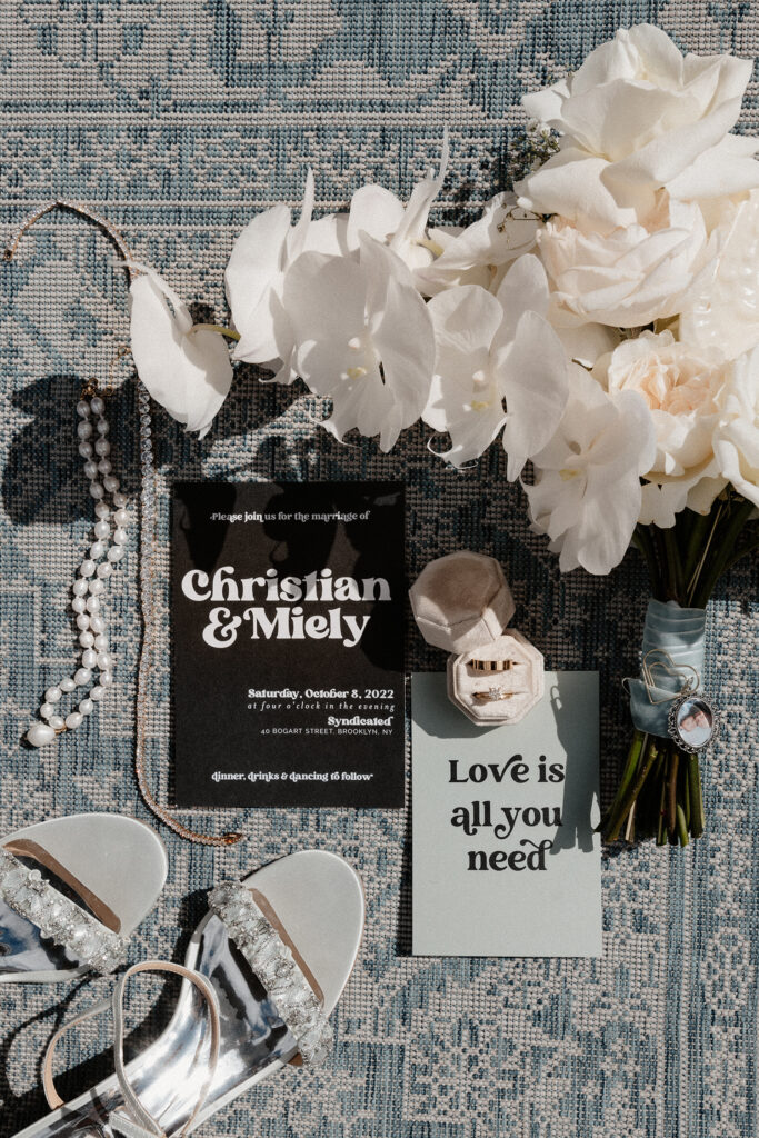 Blue, black, and white wedding details in a flatlay photo.
