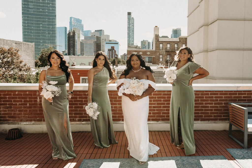 Sassy group photo of bridesmaids with the bride on a rooftop in Brooklyn.