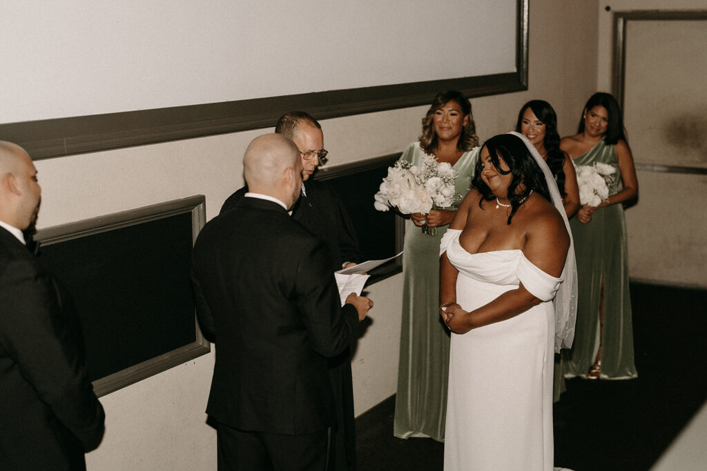 Groom reading vows during their ceremony in a movie theatre.