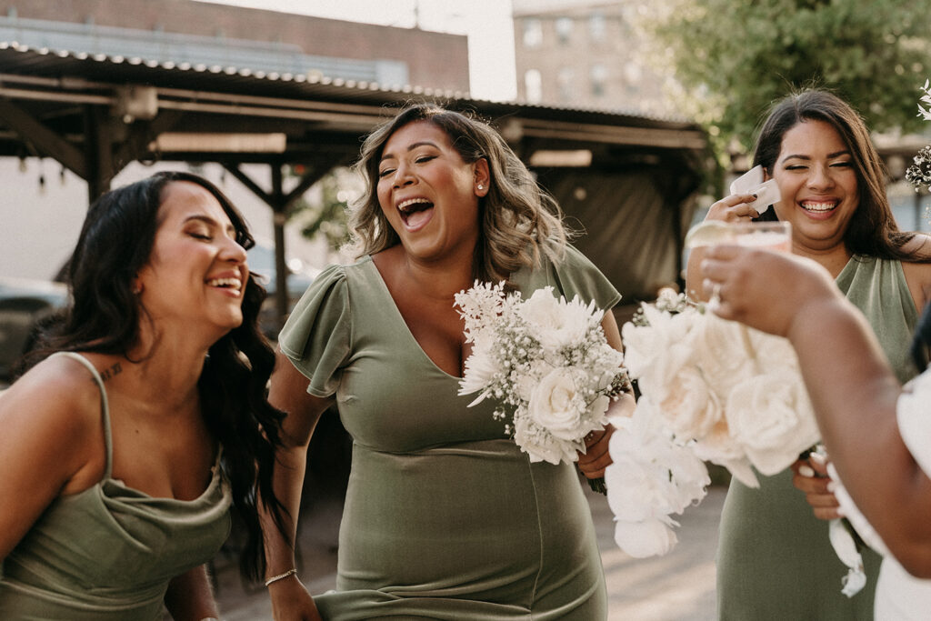 Bridesmaids laughing wildly after the ceremony outside of Syndicated.