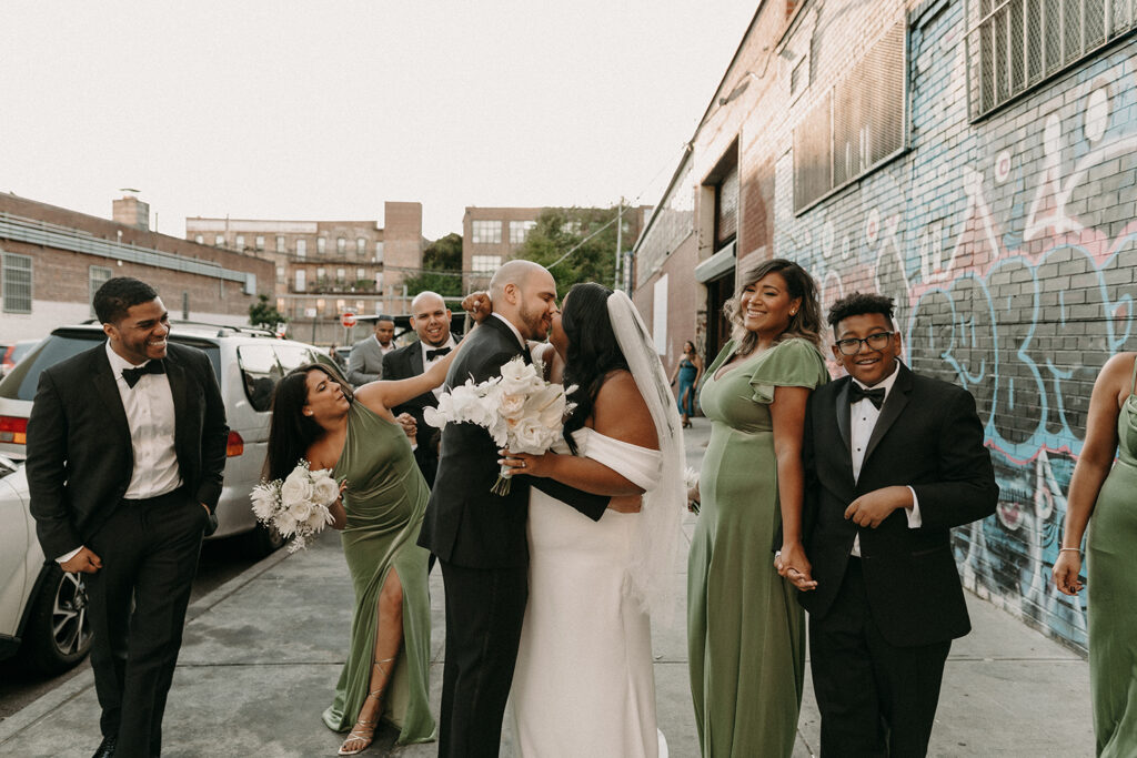Wedding party group photo of them walking outside of the Syndicated Movie Theatre and Bar in Bushwick Brooklyn, NY.