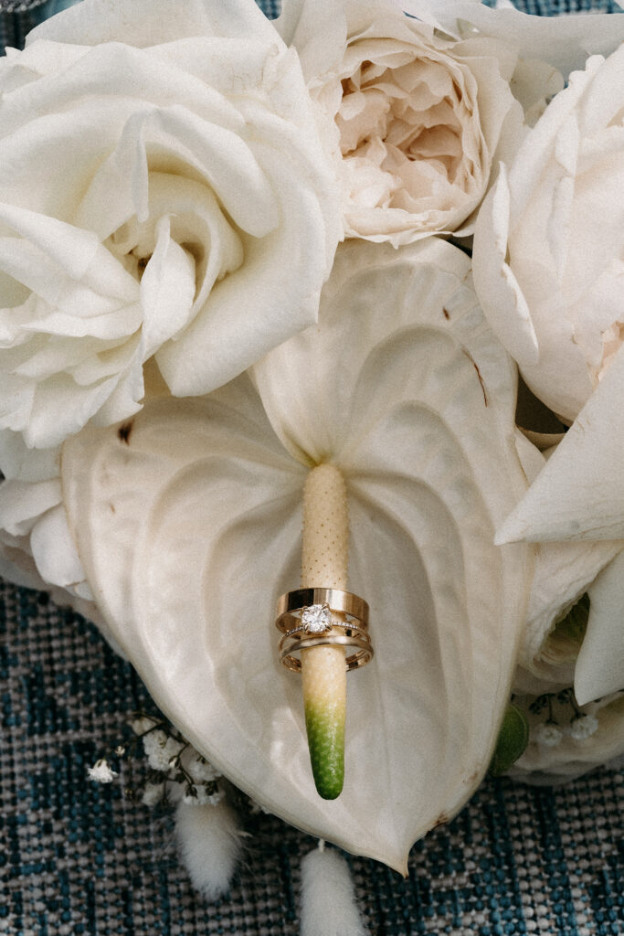 Close up photo of wedding rings and bouquet.