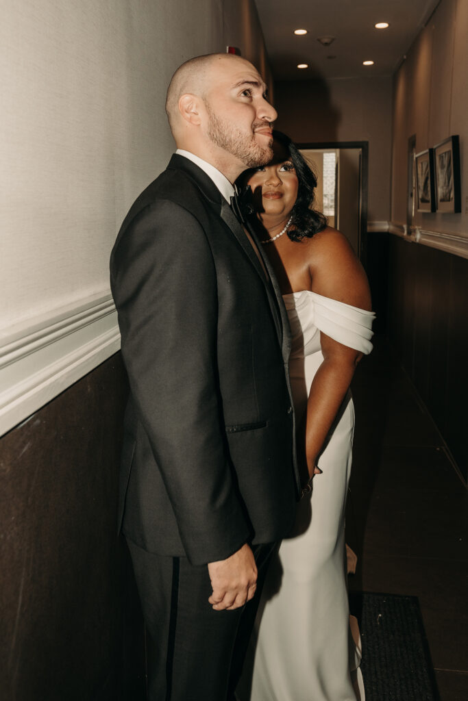 Direct flash photo of a bride and groom waiting together for an elevator to go take pictures.