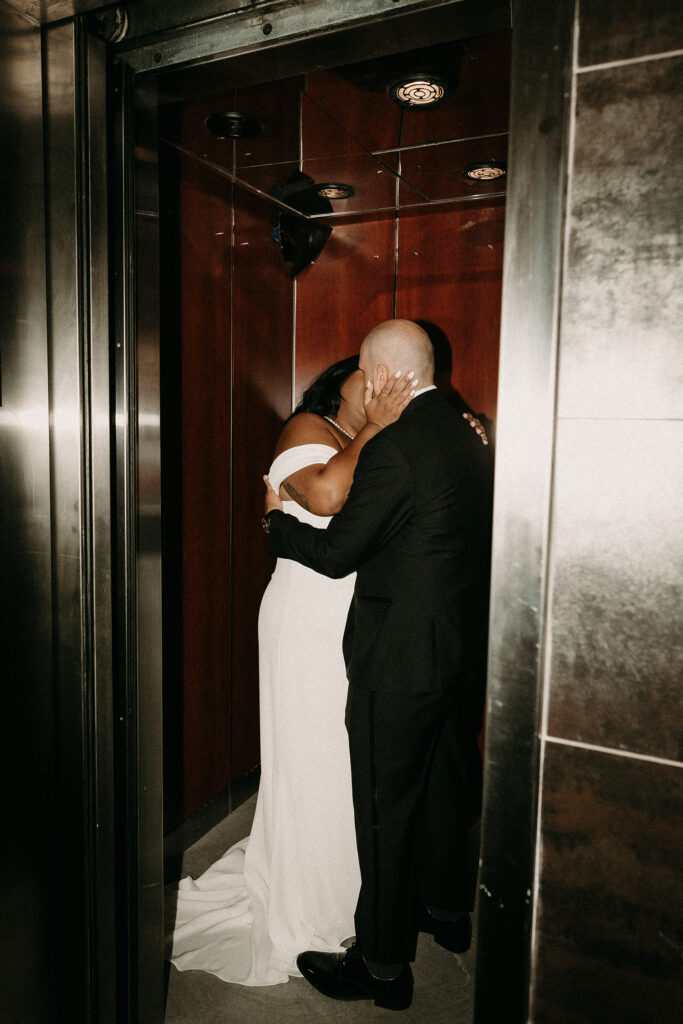 Direct flash elevator photo of a bride and groom kissing.