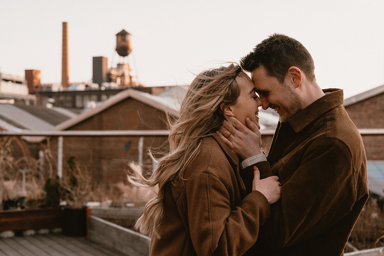 Cozy rooftop snuggles during an engagement photoshoot in Williamsburg during golden hour.