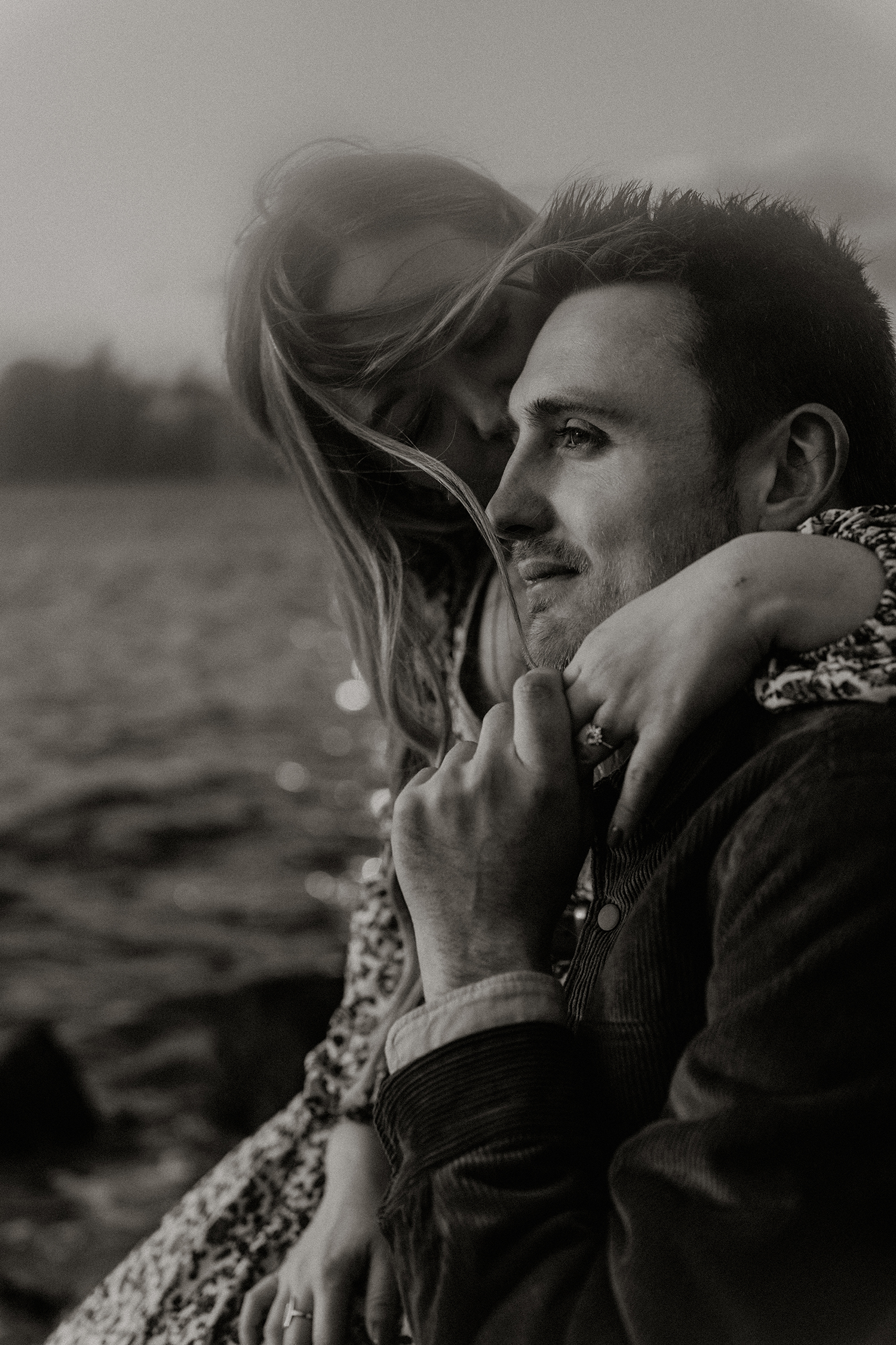 Black and white engagement photos on a rocky beach in Williamsburg.