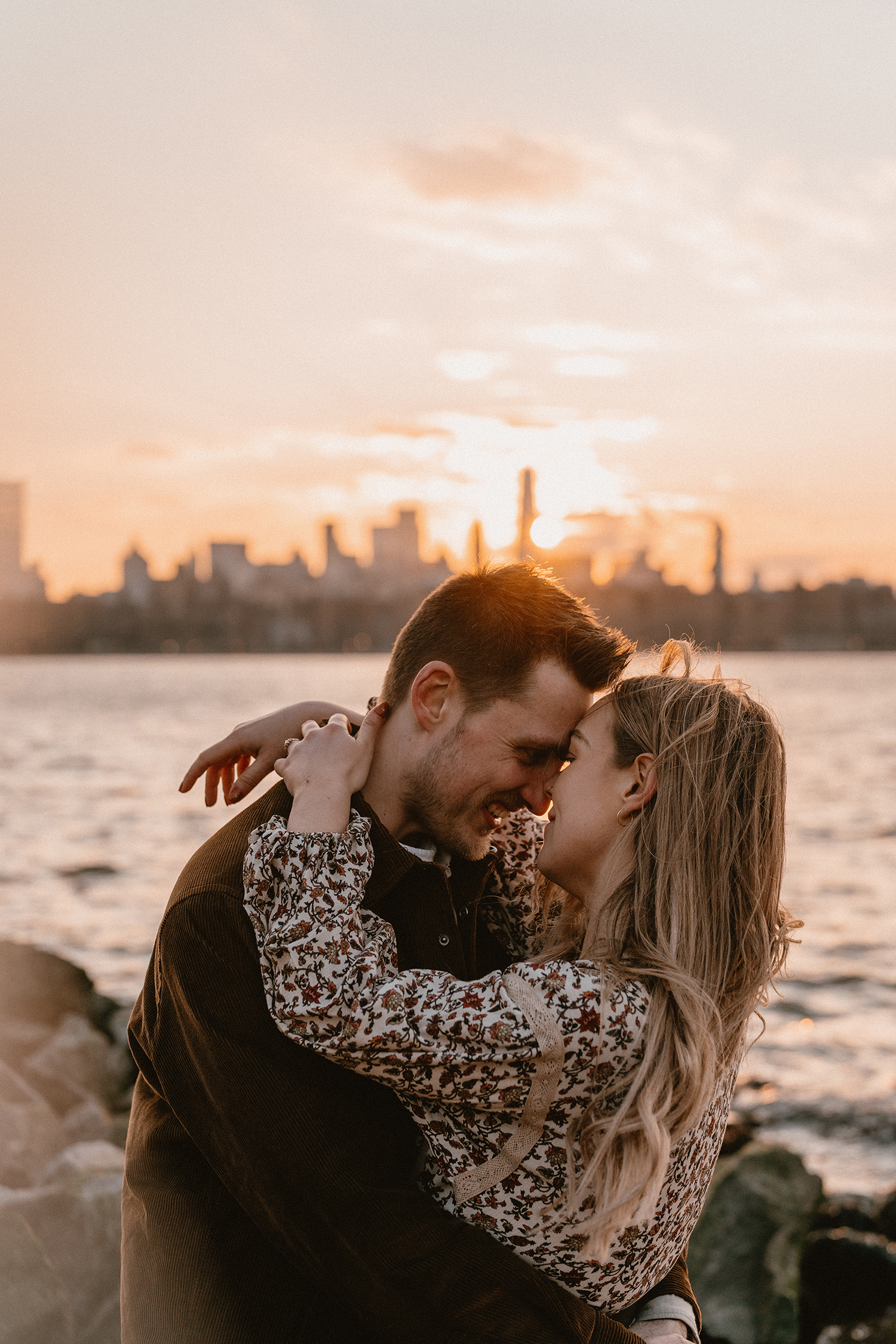 Engagement photos looking out over the NYC skyline during golden hour.