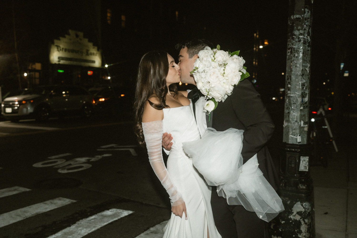 Bride and groom sneak a kiss while walking over to the Greenpoint Loft for their wedding reception.