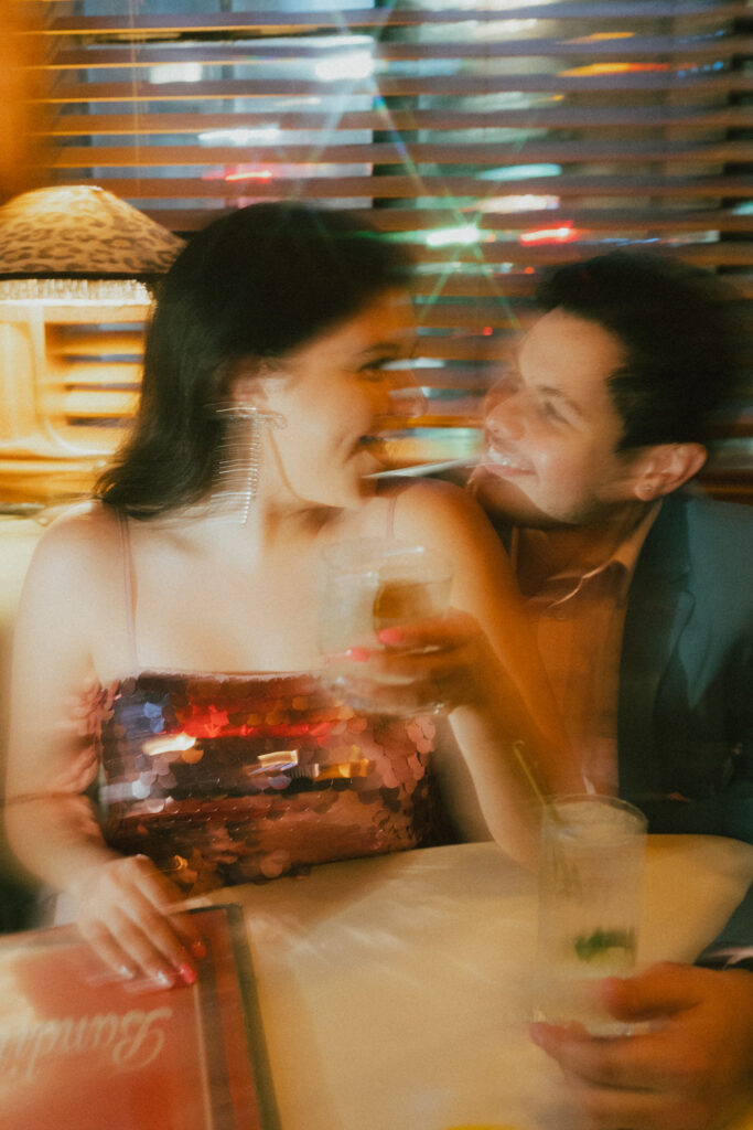A candid and colorful moment between a couple in a retro cocktail bar in Manhattan.