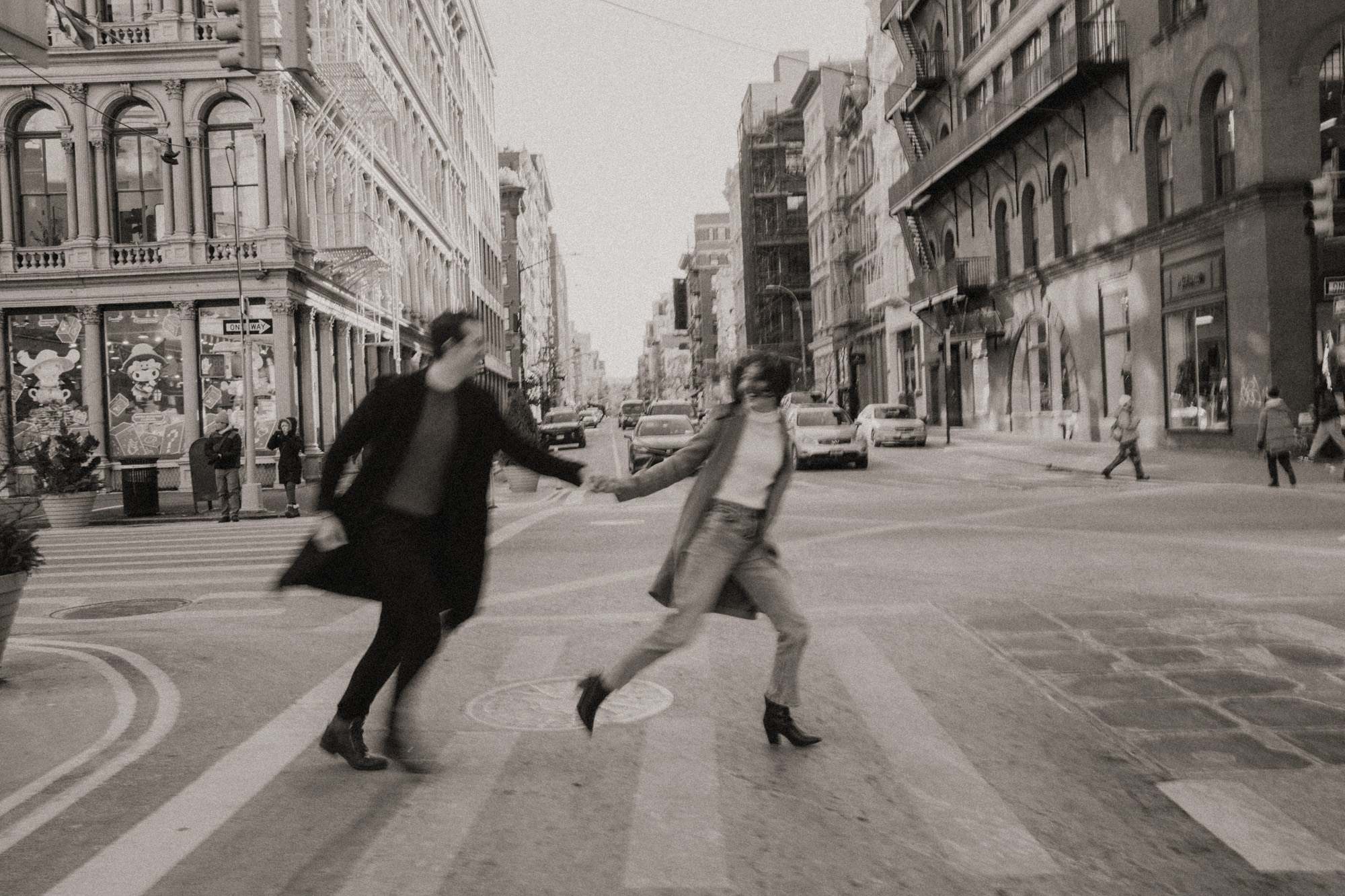 Black and white photo of a couple running through a crosswalk.