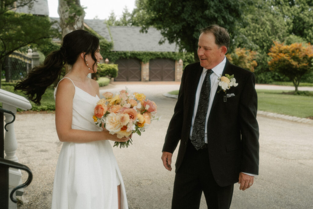 A bride spins around to show her father her full wedding look during the father/daughter first look at her wedding.