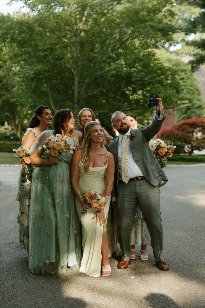 Bridal party takes a selfie together while waiting on the couple for wedding party photos.