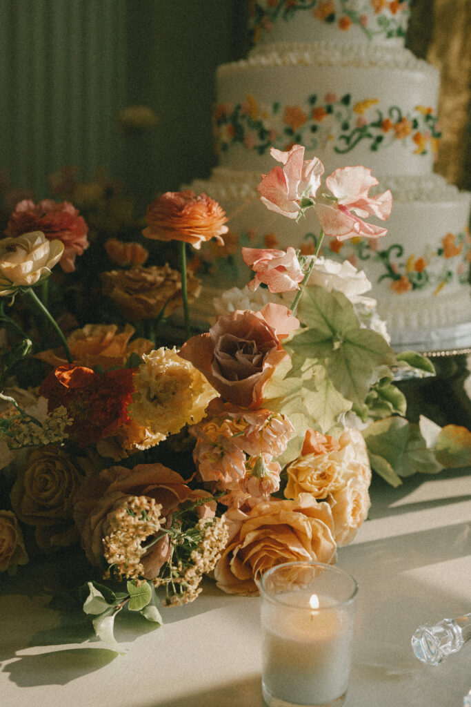 Close up details of the florals adorning the cake table with the cake in the background.