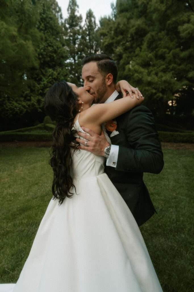 A bride falling into the arms of her groom while running around in a luxurious garden at the Ashford Estate.