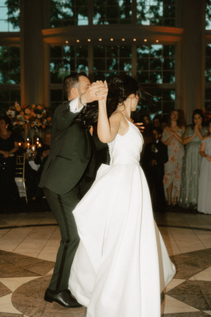 A bride and groom dance a choreographed number during their first dance at their luxury wedding reception.