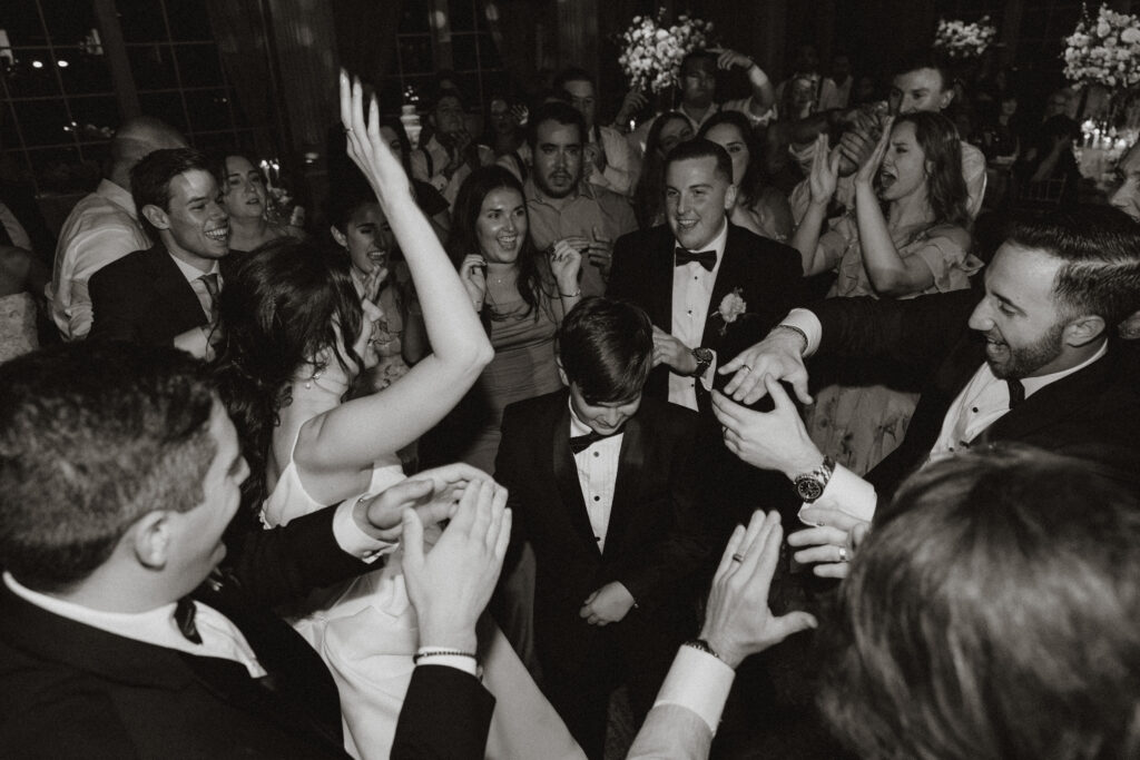 A bride, groom, and their son dance amongst their friends at their wedding reception at the Ashford Estate.