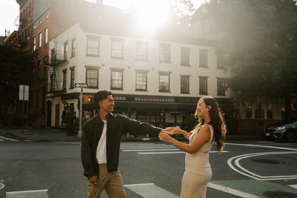 Playful engagement session during golden hour caught sun flare while dancing in the street