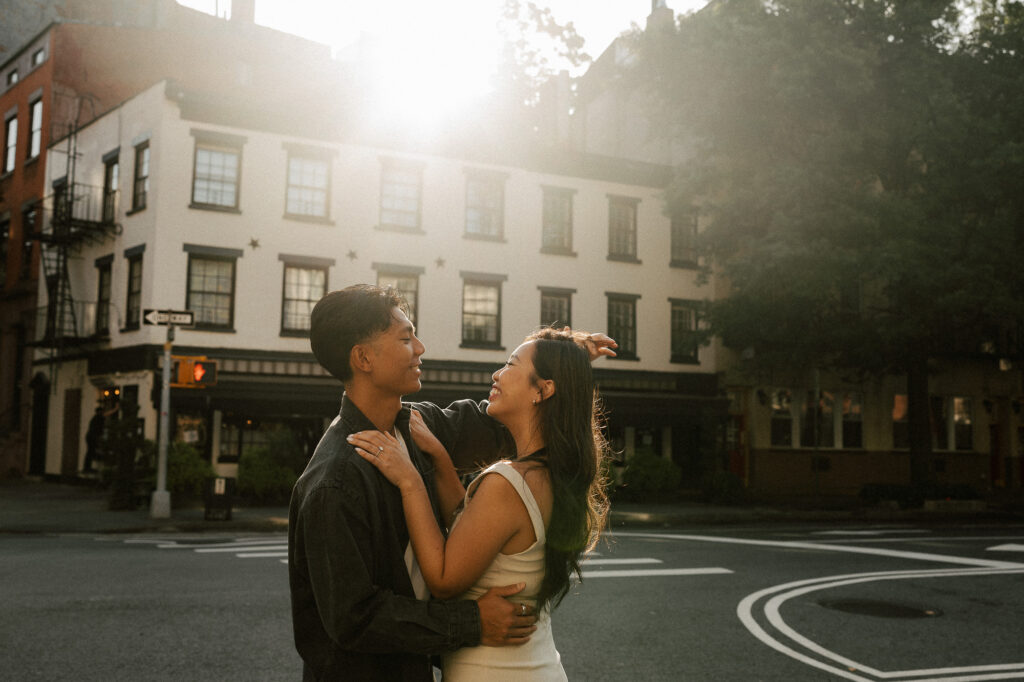 Playful engagement session during golden hour caught sun flare while dancing in the street