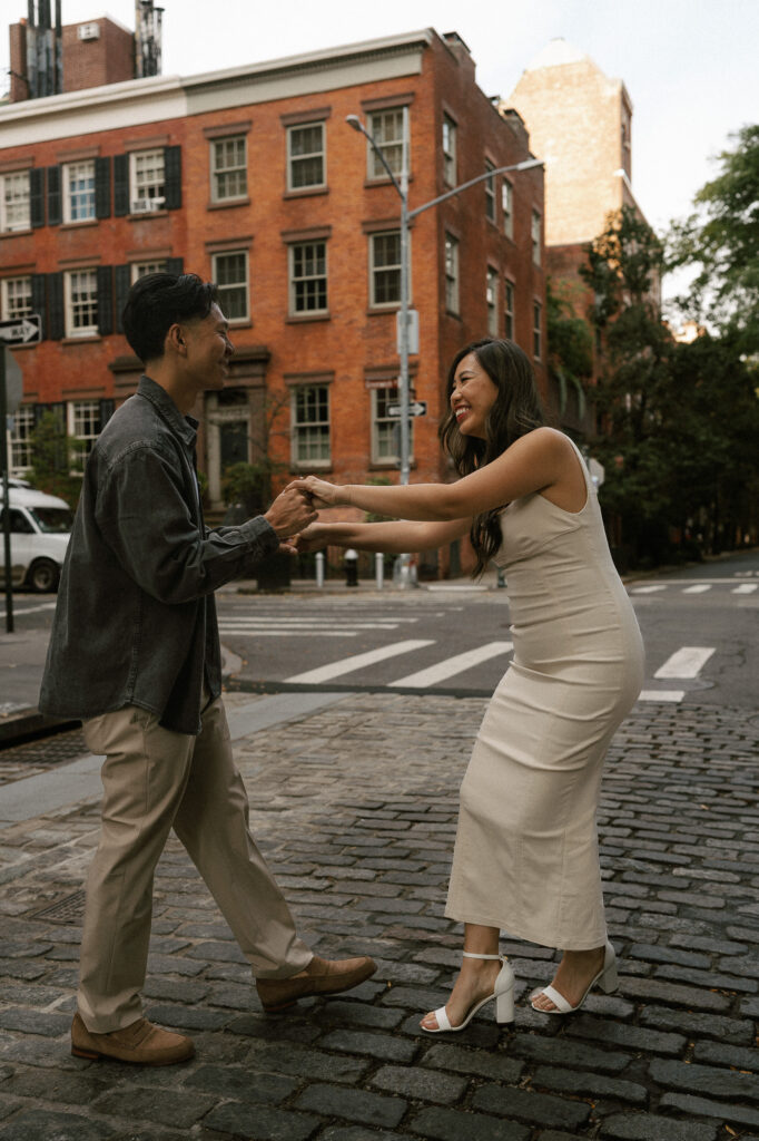 dancing engaged couple on the iconic NY cobble stoned street in West Village