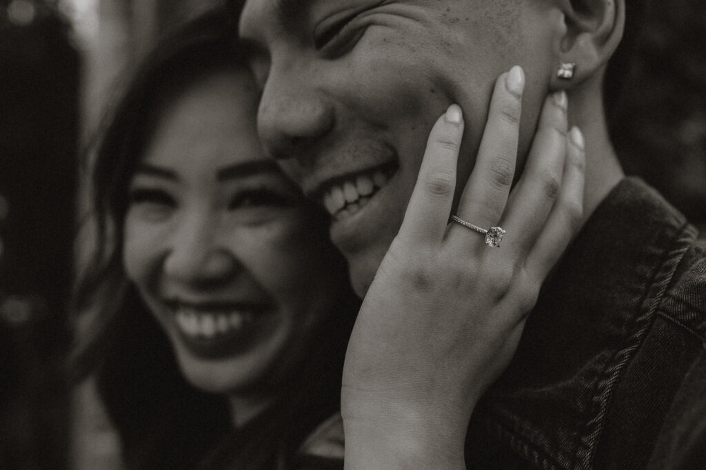 Showing off engagement ring during couples photo session - Black and white image