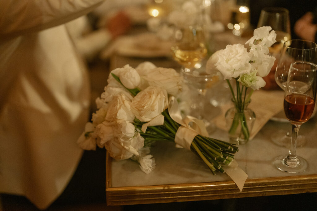 detail shot during dinner of the bouquet casually resting on corner of table 