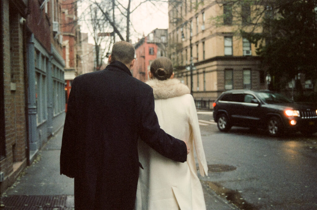 Bridal couple walking away from the camera in the streets of Soho