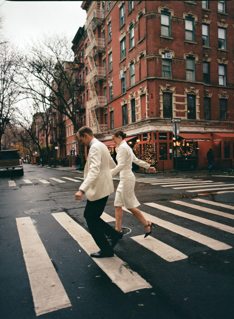 film shot of newly weds running through a crosswalk