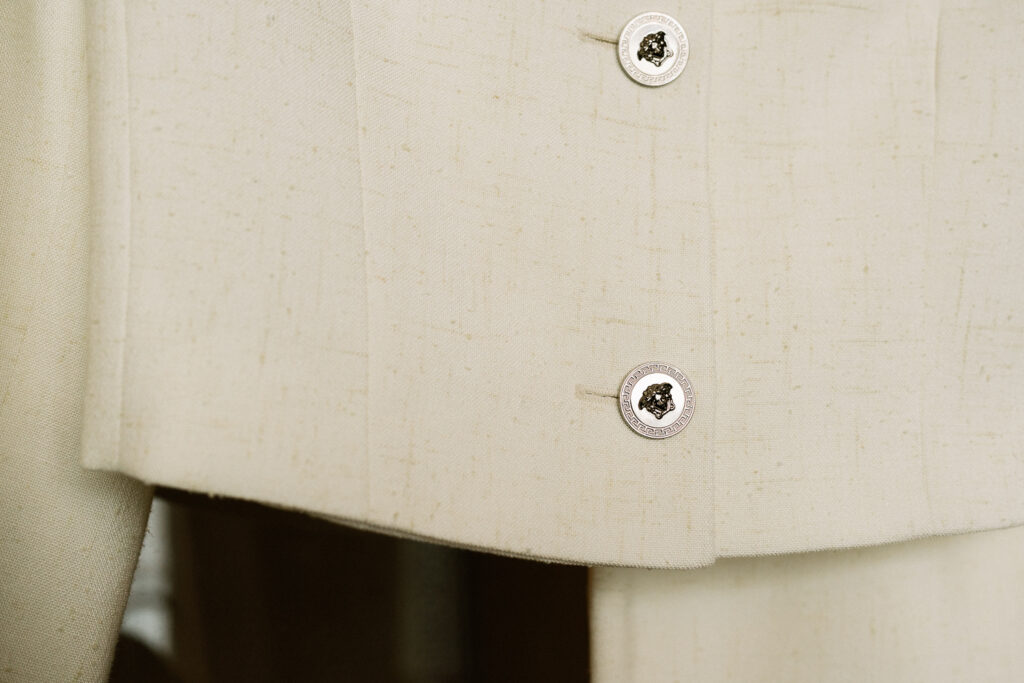 close up of buttons on Versace cream suit jacket as alternative to wedding dress