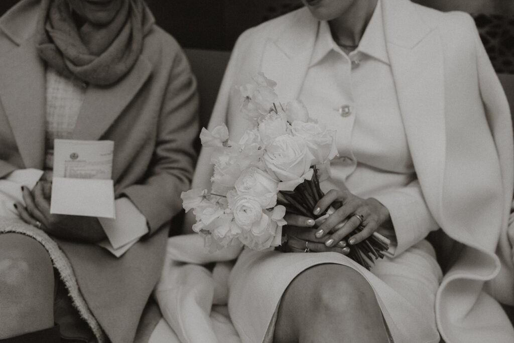 mother of bride waiting with bride holding bouquet and marriage license