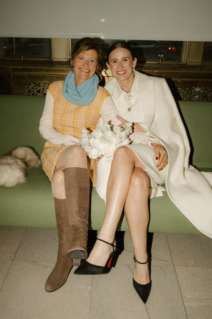 Bride's mother waiting with bride holding bouquet 