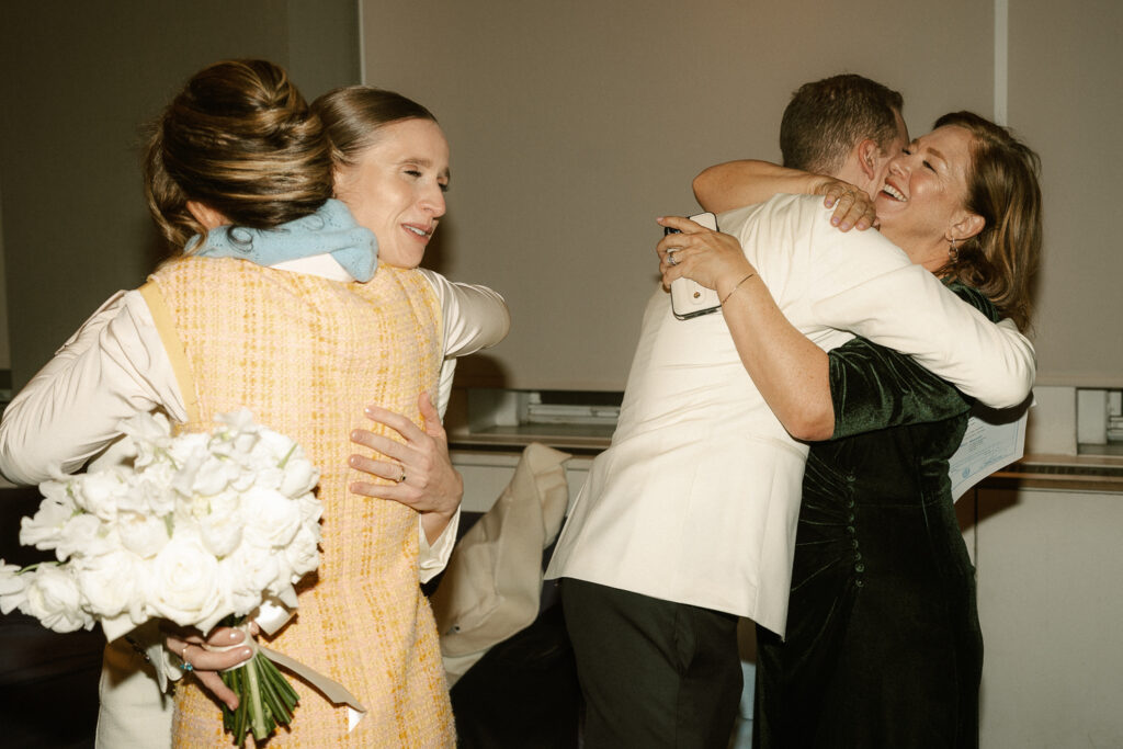 bride and groom hug their mothers