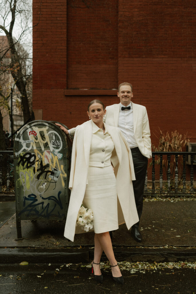 Brick wall background made couple pop in their winter white elopement suits