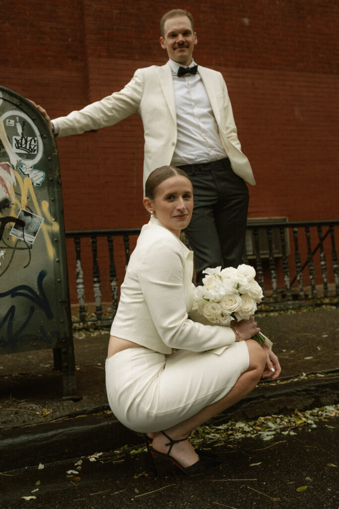 Just married couple captured in winter white in front of brick wall in West Village of New York