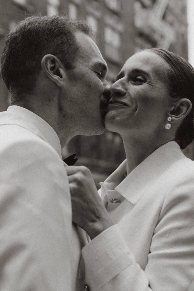 black and white image of a quick kiss before couple go into reception