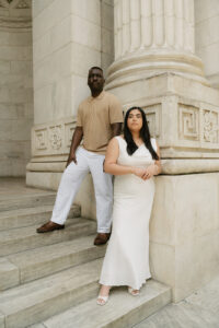 Engaged couple posed in a lean against mammoth marble columns of main branch of library in NYC