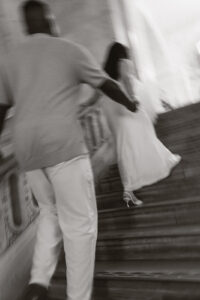 Cinematic engagement shoot of couple on marble steps of library in New York